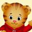 A close-up of a friendly, tiger wearing a red sweater and waving.